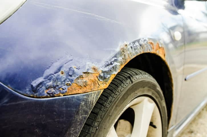 A close up on the damage caused by winter and salt that makes a car wing rust