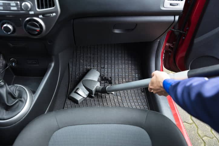 person hoovering car footwell