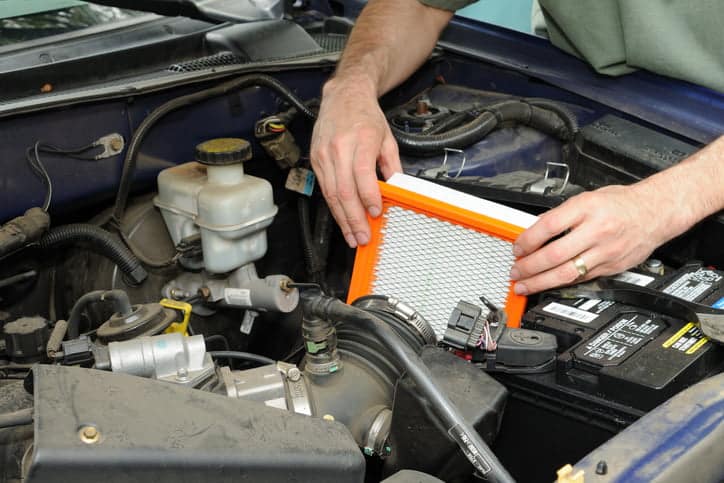 Man replacing an automotive air filter.