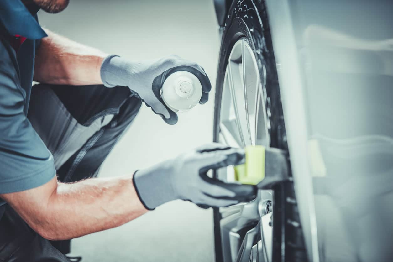 Man cleaning car wheels with spray