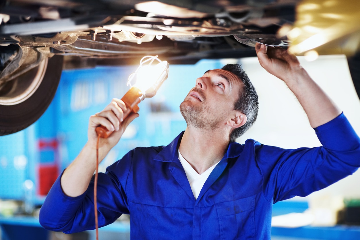 mechanic checking underneath a car