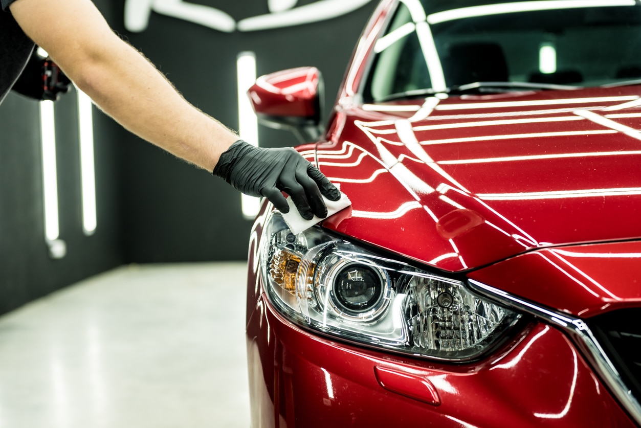 Car service worker applying nano coating on a car detail